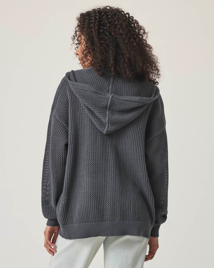 Woman wearing a netted gray zip up hooded sweater cardigan