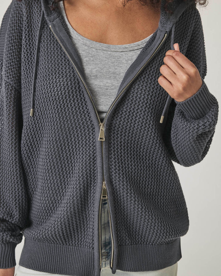 Woman wearing a netted gray zip up cardigan