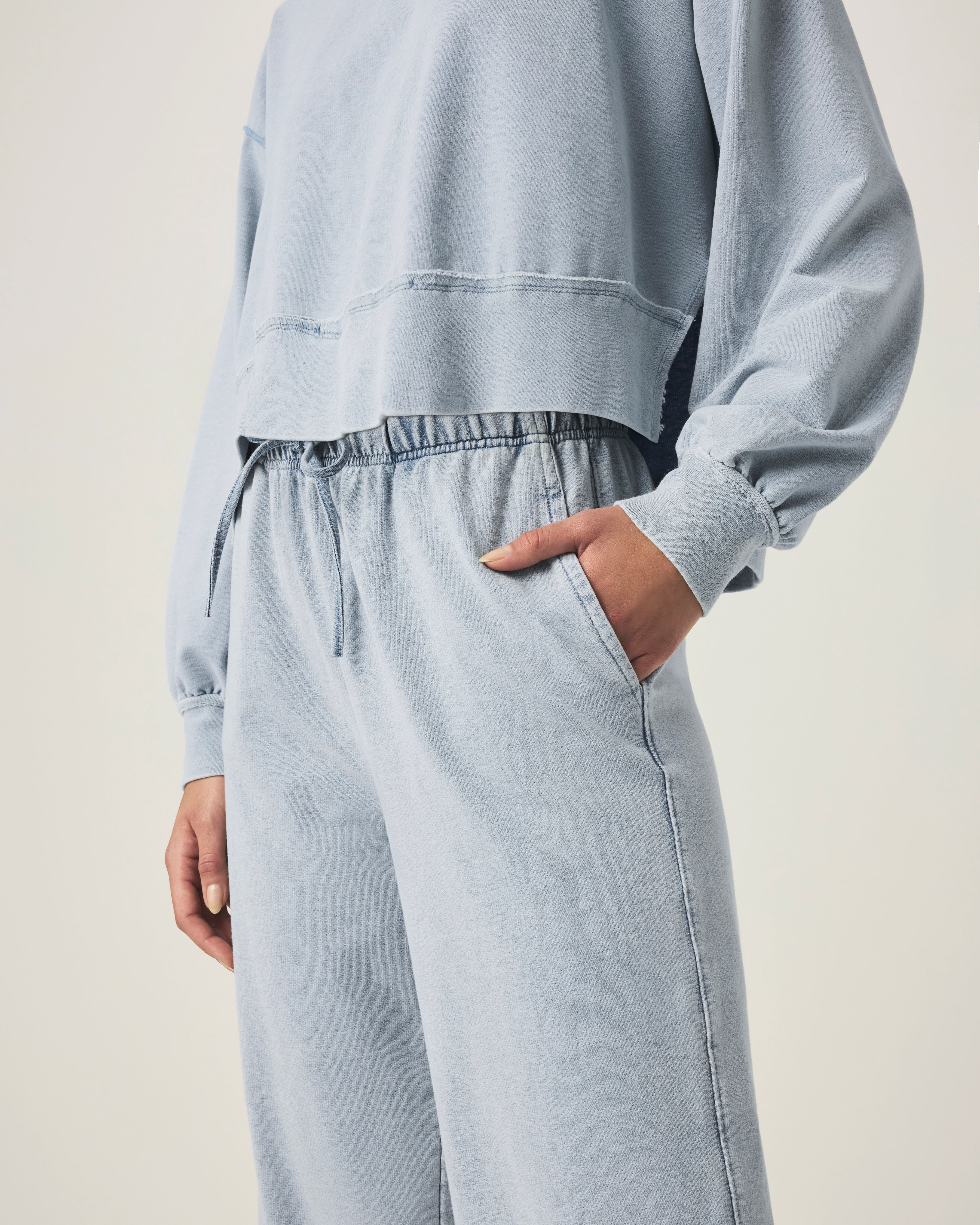 person wearing light blue grey terry pants with drawstring and elastic waistband