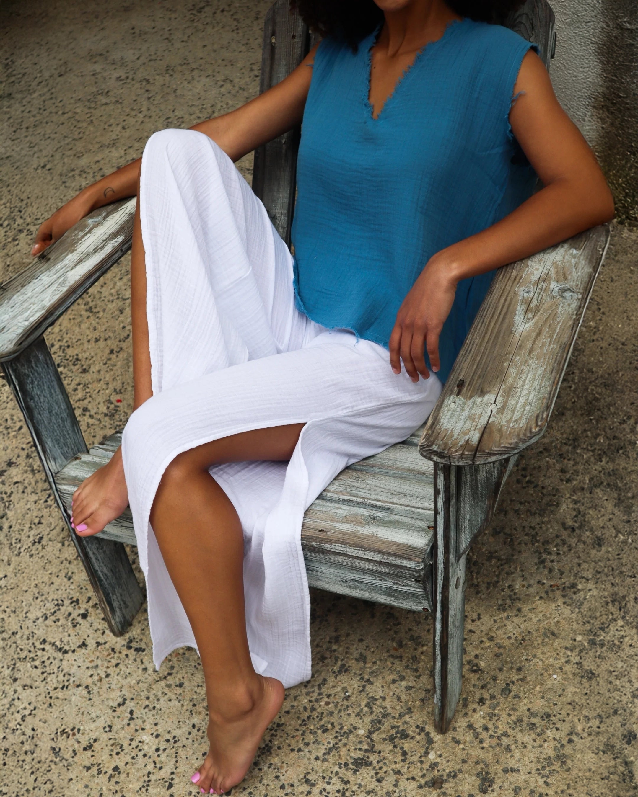 A person wearing white cotton gauze slit pants with high side seam slits