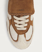 pair of pony hair cream and tan leather sneakers with a rubber sole