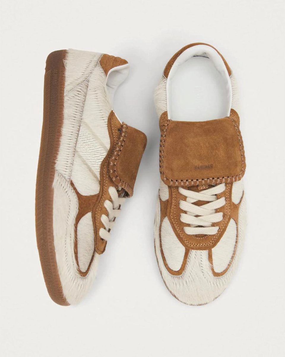 pair of pony hair cream and tan leather sneakers with a rubber sole