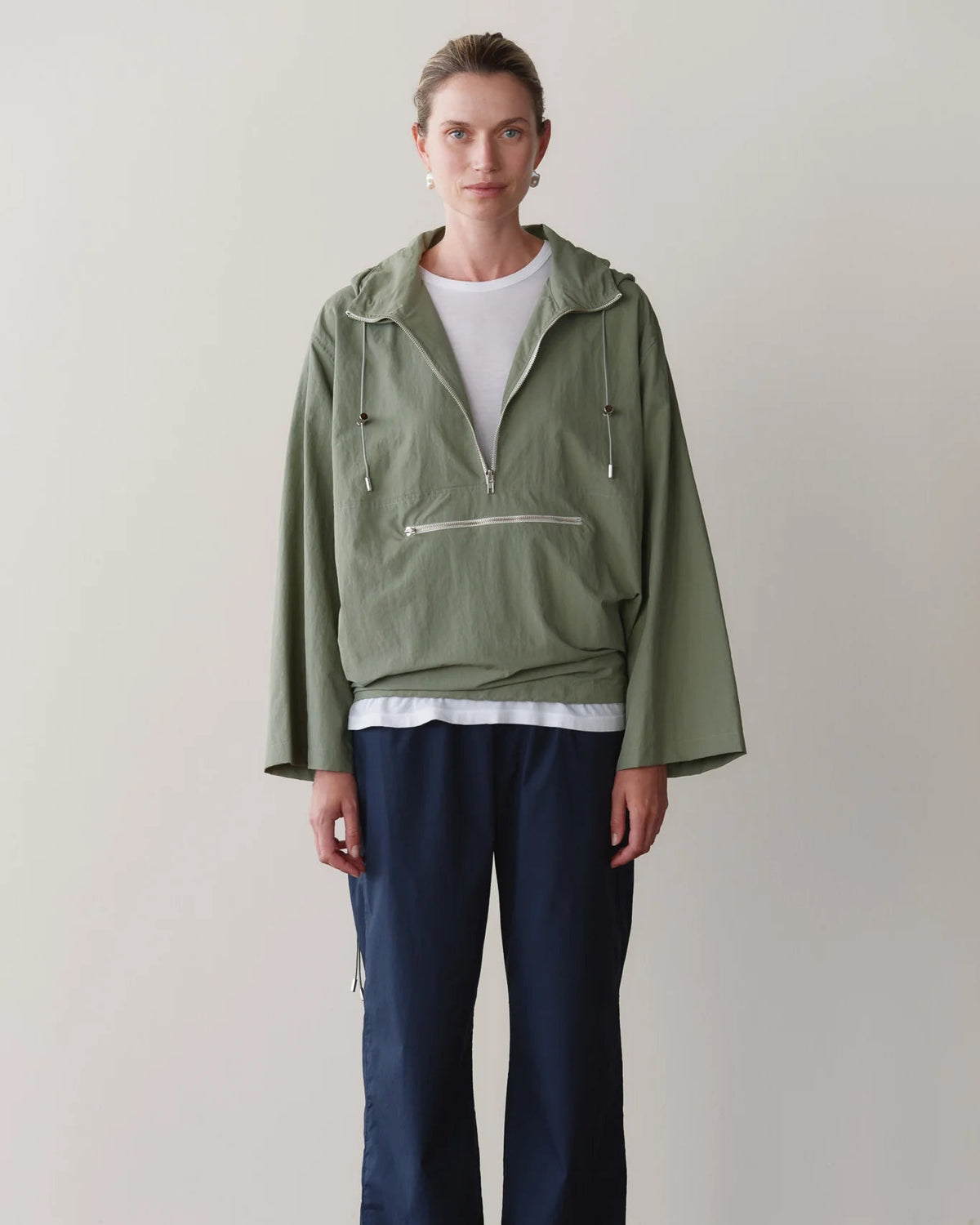 green rain jacket with wide sleeves and a hood