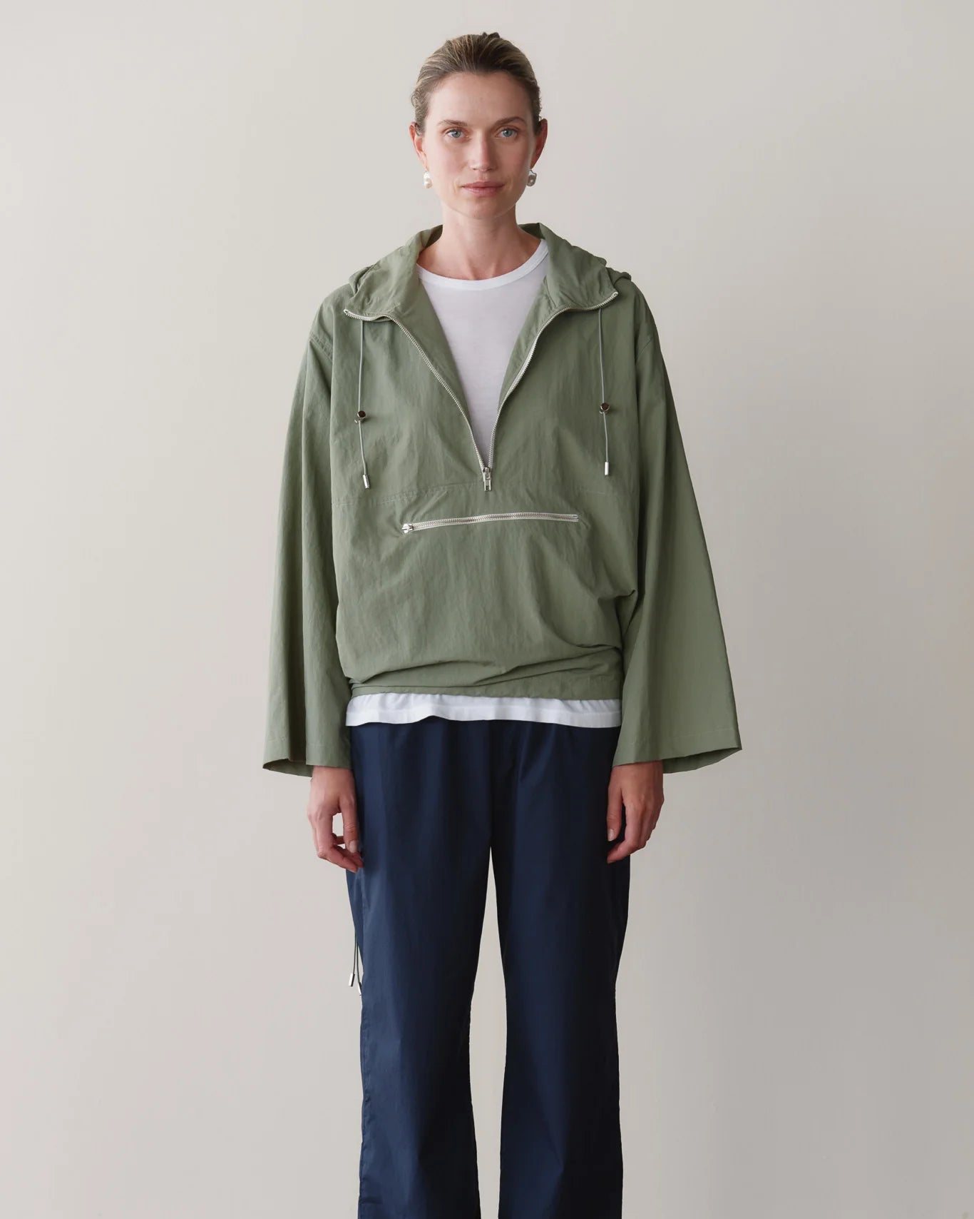 green rain jacket with wide sleeves and a hood