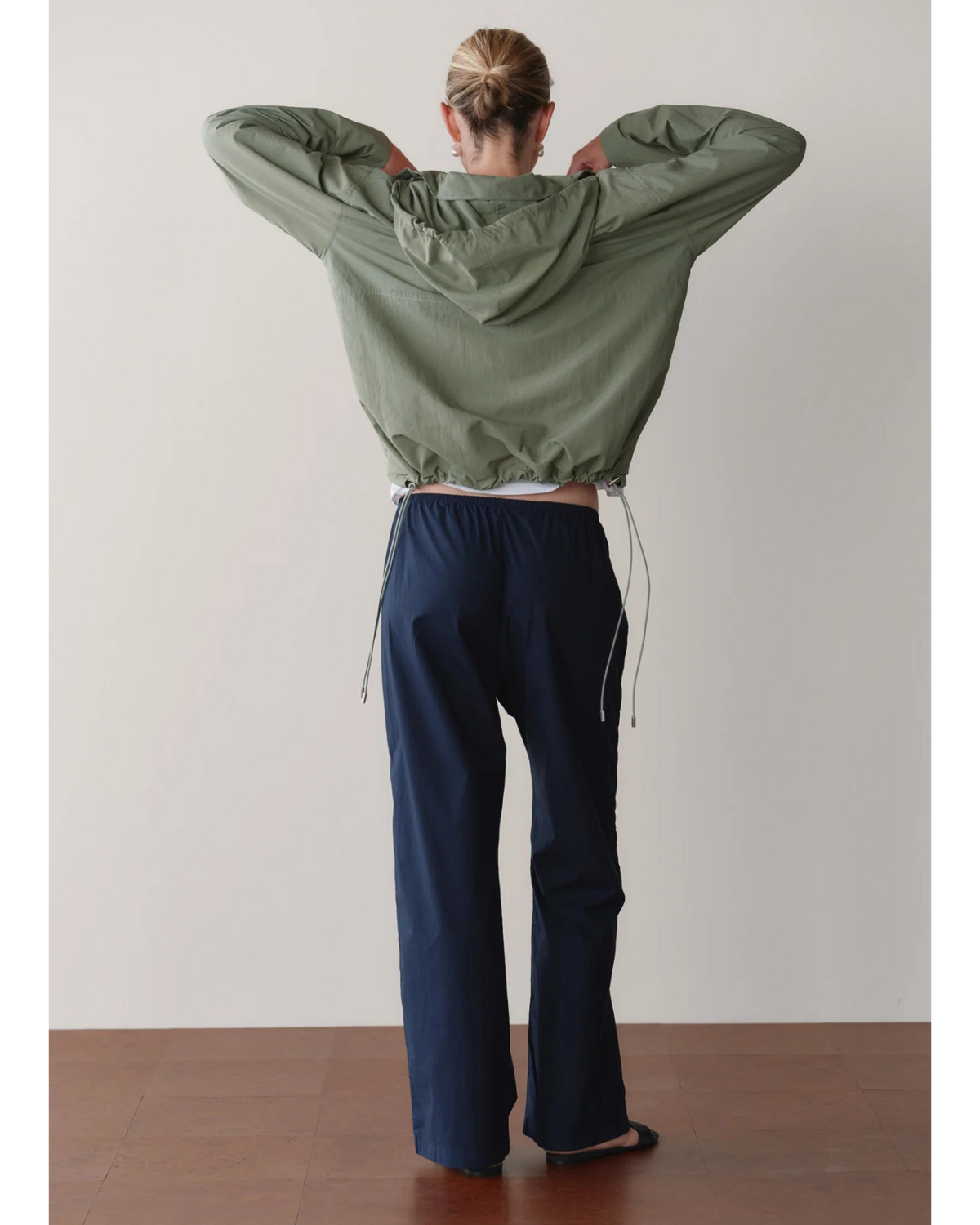 green rain jacket with wide sleeves and a hood