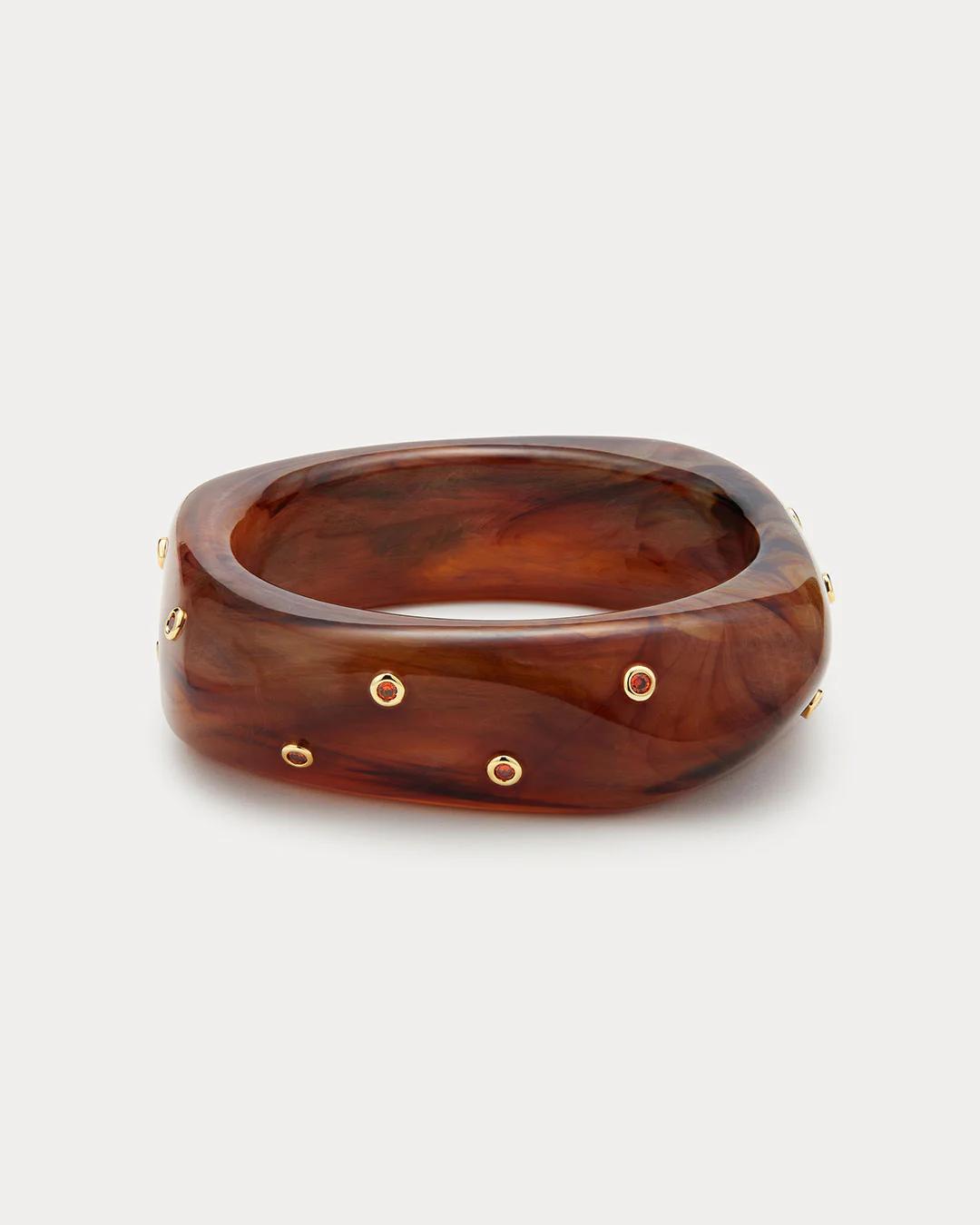 Brown bangle with gold accents on a light gray background