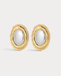 Gold and silver earrings on a light gray background