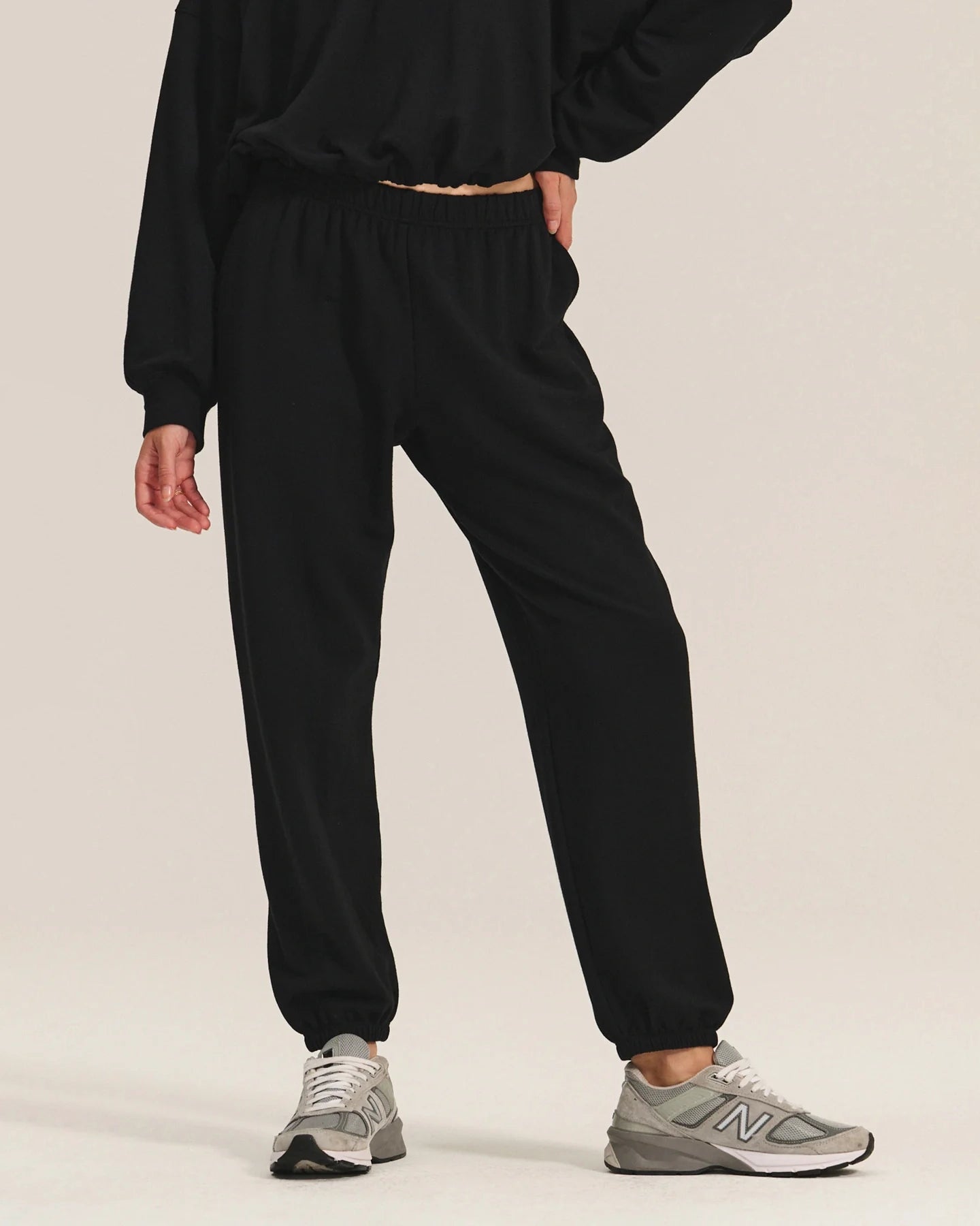 woman wearing black cotton sweatpants with a matching sweatshirt
