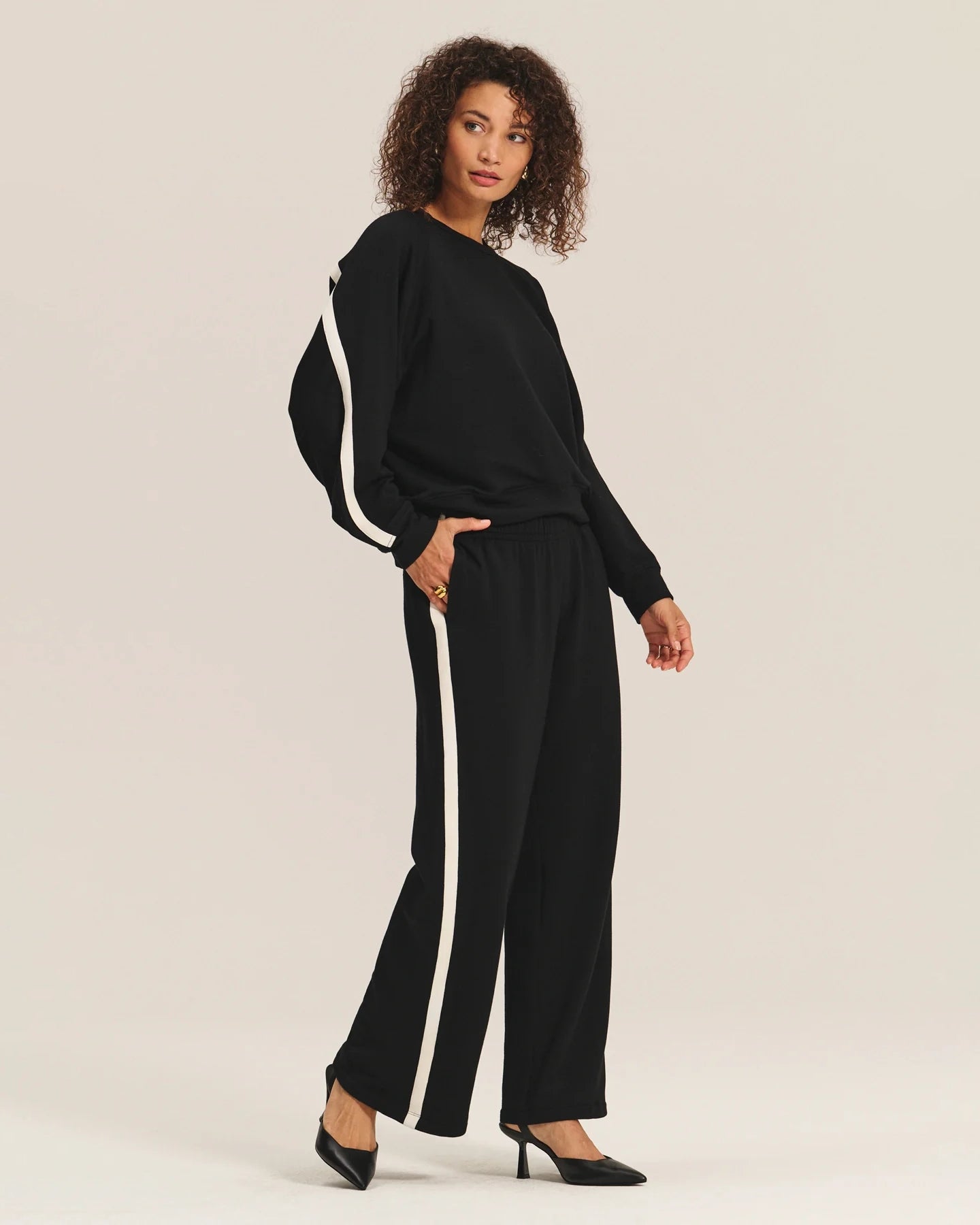 Woman wearing a black outfit with white stripes and matching trousers