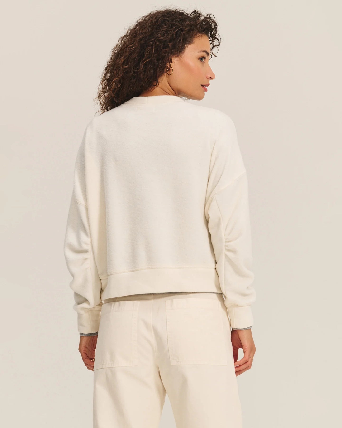 Woman wearing a cream sherpa textured sweater