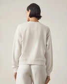 woman wearing a light gray sweatshirt from behind