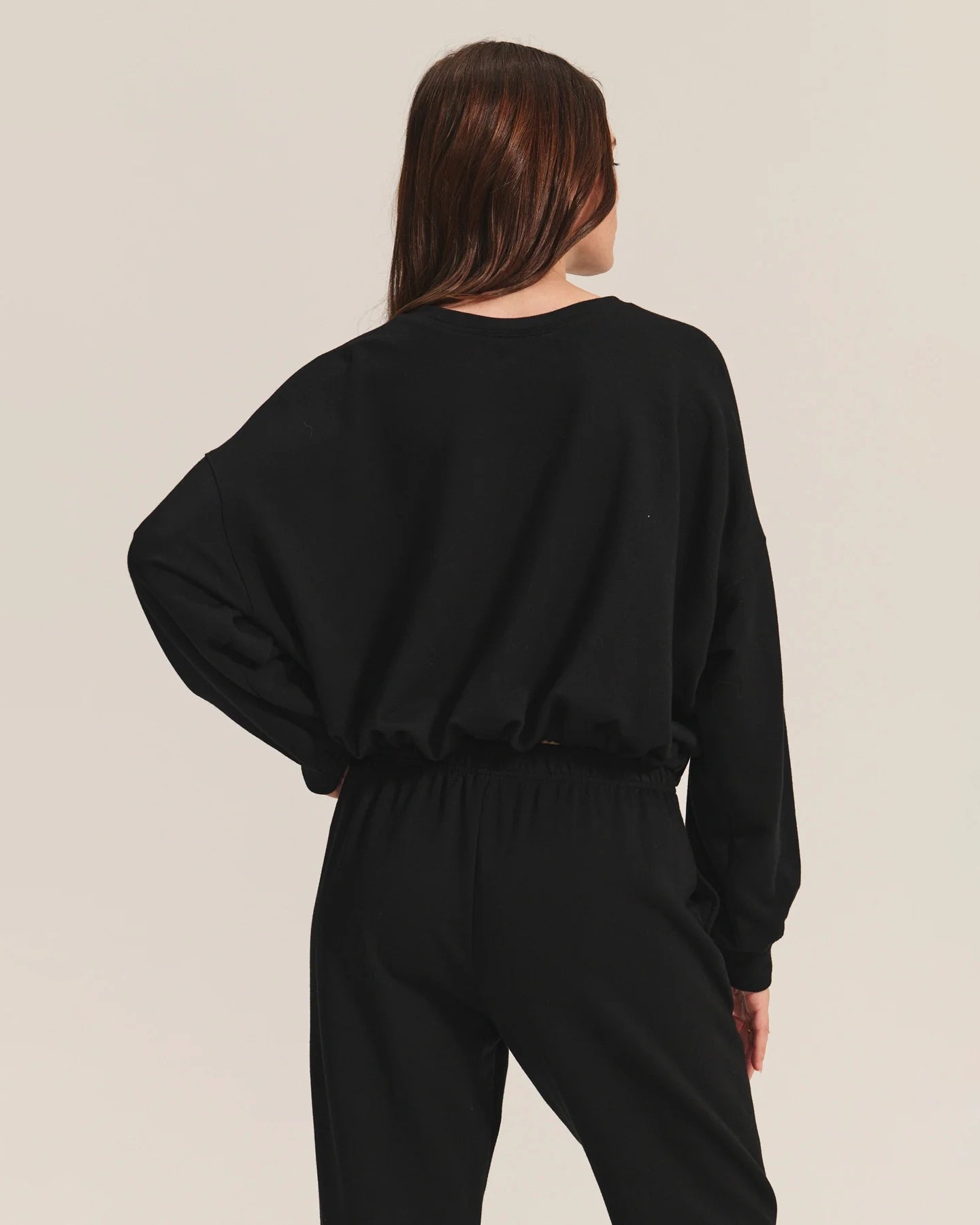 Woman wearing a black cotton sweatshirt with matching joggers