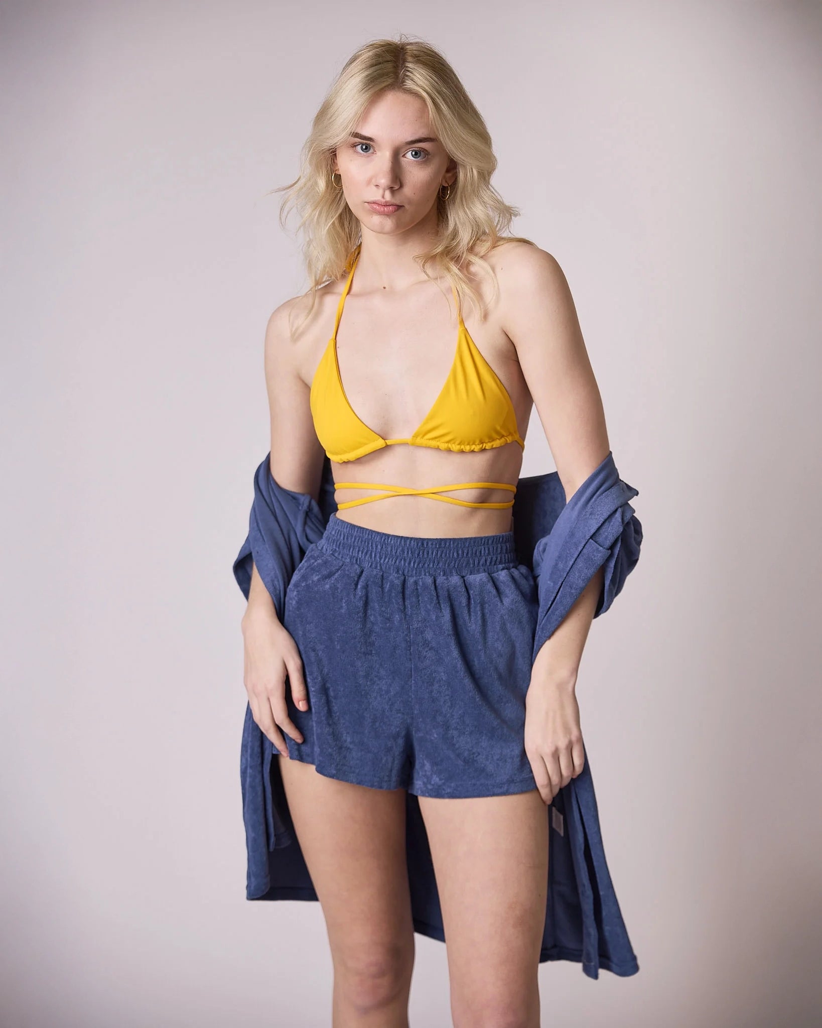 woman wearing blue terry cloth shorts and matching button down top