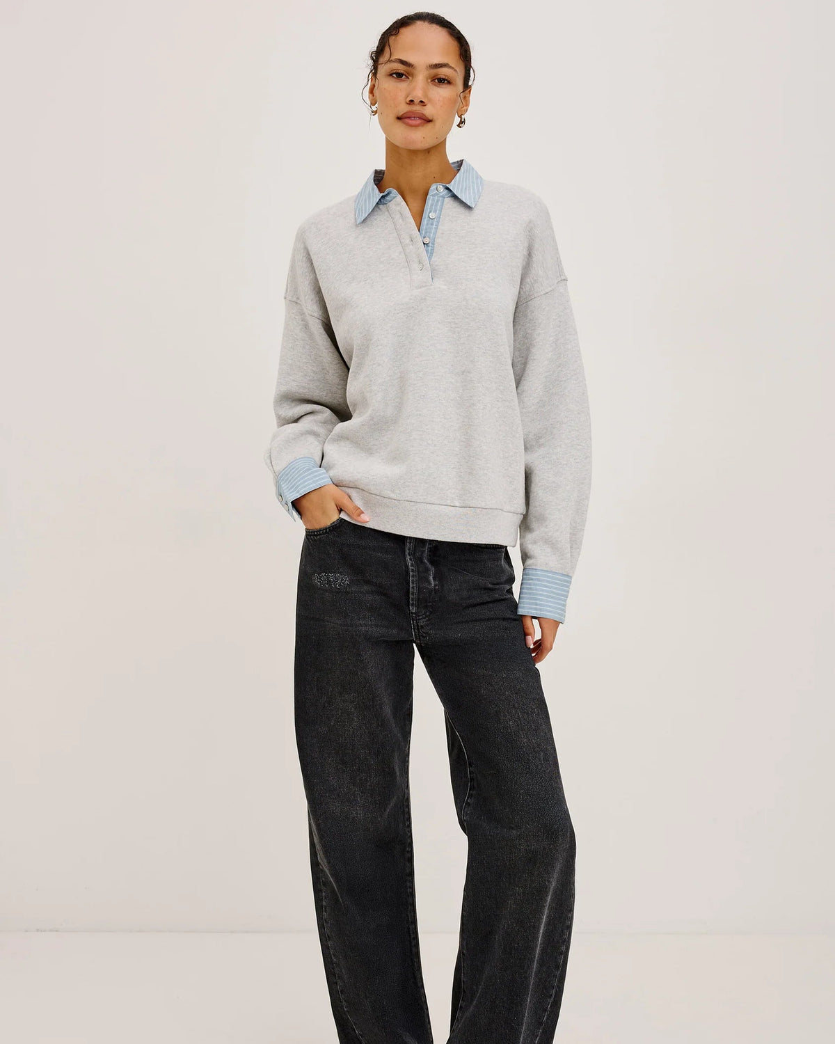 grey pullover sweatshirt with half buttons down and a blue striped collar