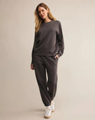 Woman wearing a dark gray cotton sweatshirt with matching sweatpants