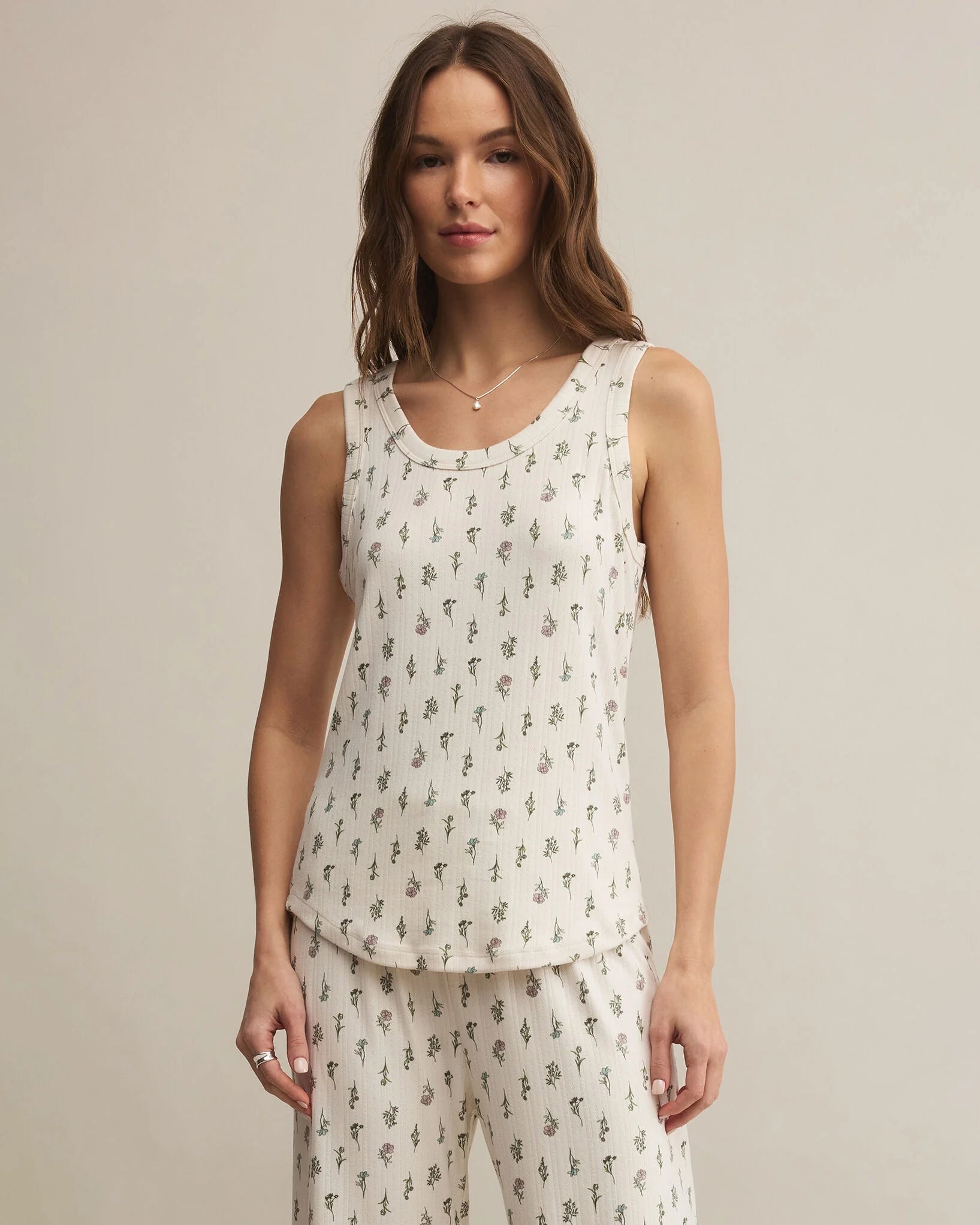 Woman wearing a white sleeveless top with a floral print