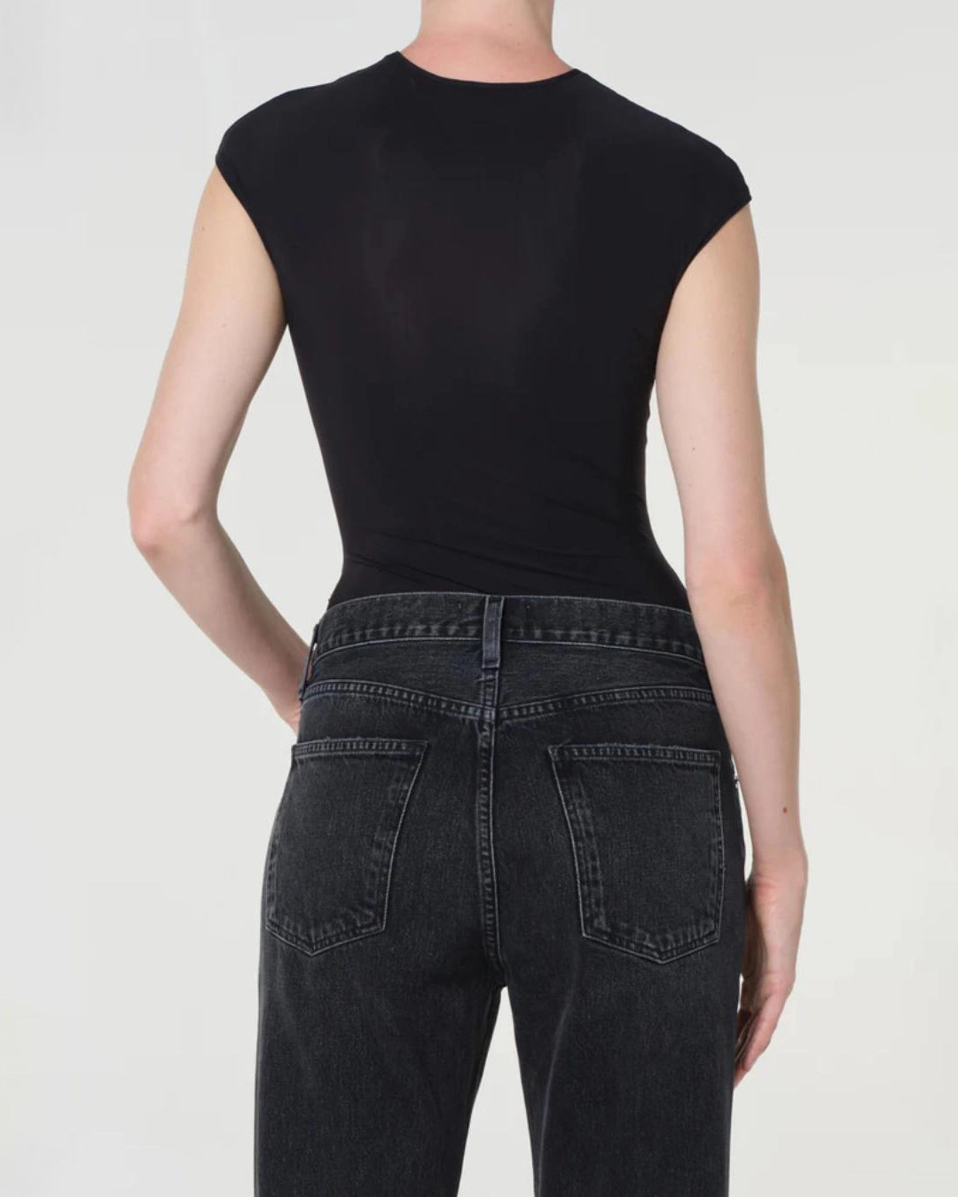 woman wearing a black bodysuit with a corset design by Agolde