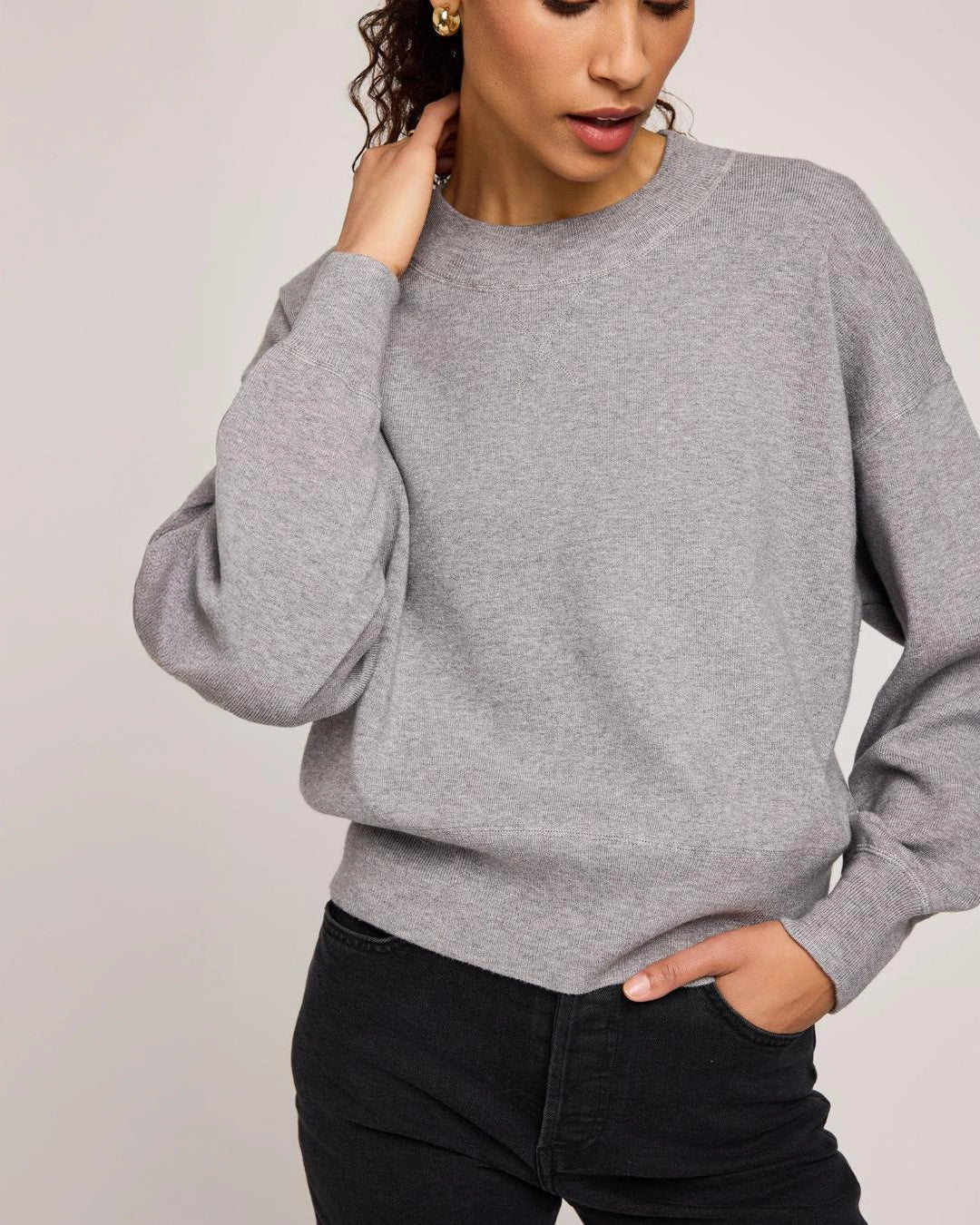 Woman wearing a gray crew neck sweater