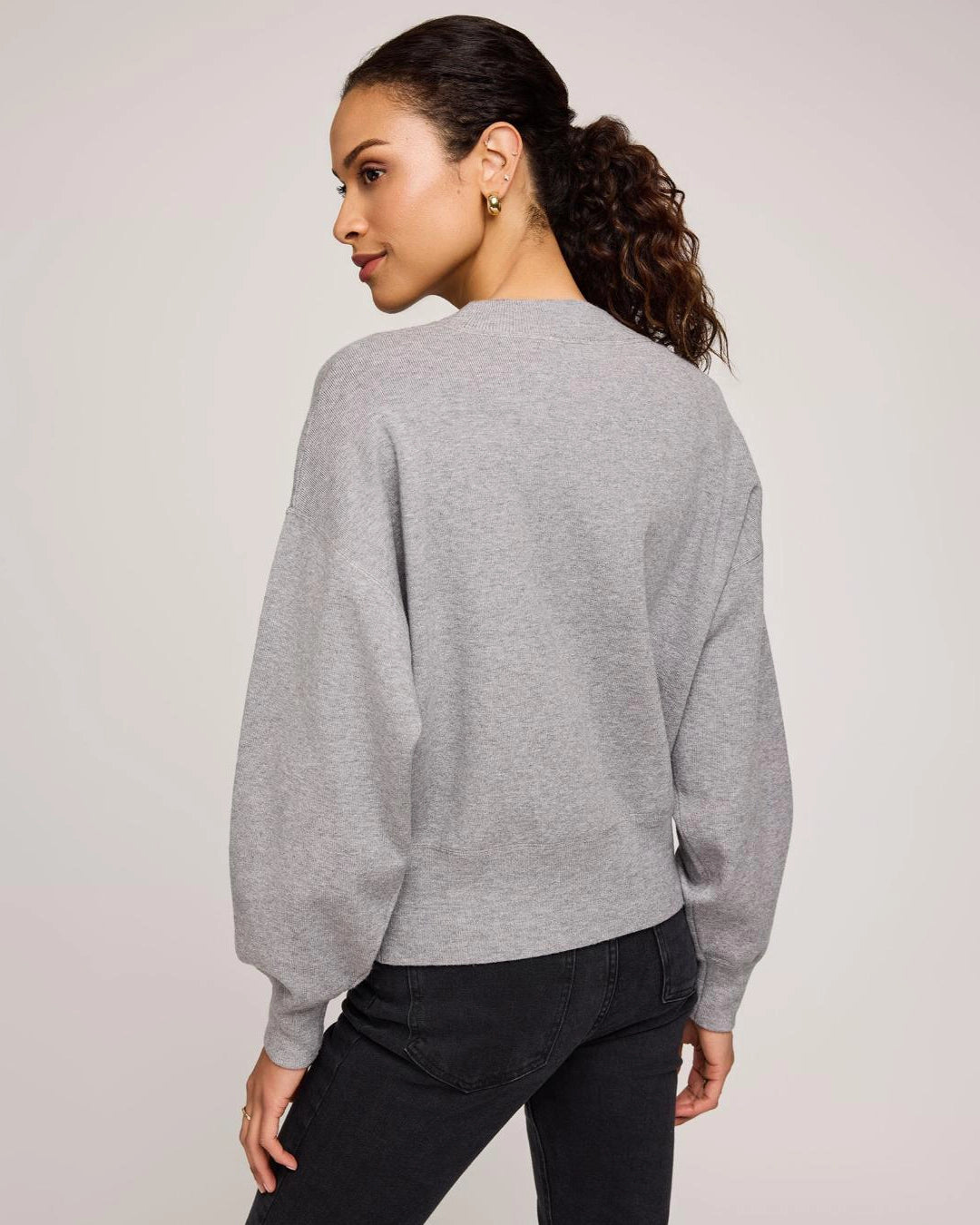 Woman wearing a gray crew neck sweater