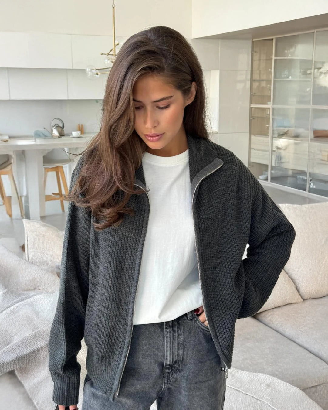 Woman wearing a dark gray zip up knit jacket