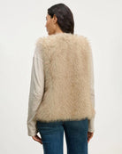 Woman wearing a beige faux fur vest