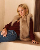 Woman wearing a beige faux fur vest