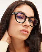 a woman wears a pair of black bold framed eyeglasses for blue light by Barner