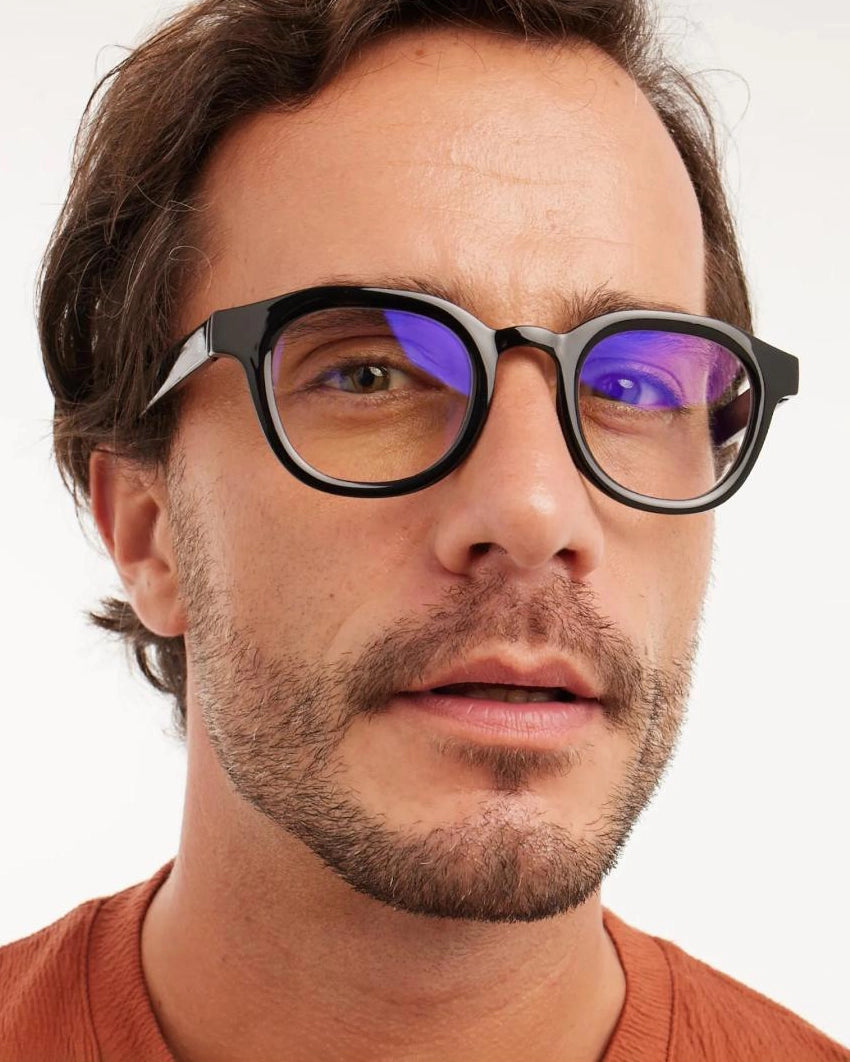 a man wears a pair of black bold framed eyeglasses for blue light by Barner