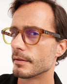 a man wears a pair of tortoiseshell round framed eyeglasses for blue light by Barner