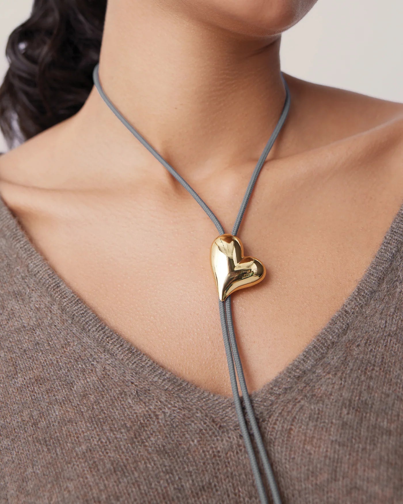 string tie necklace with a gold heart pendant