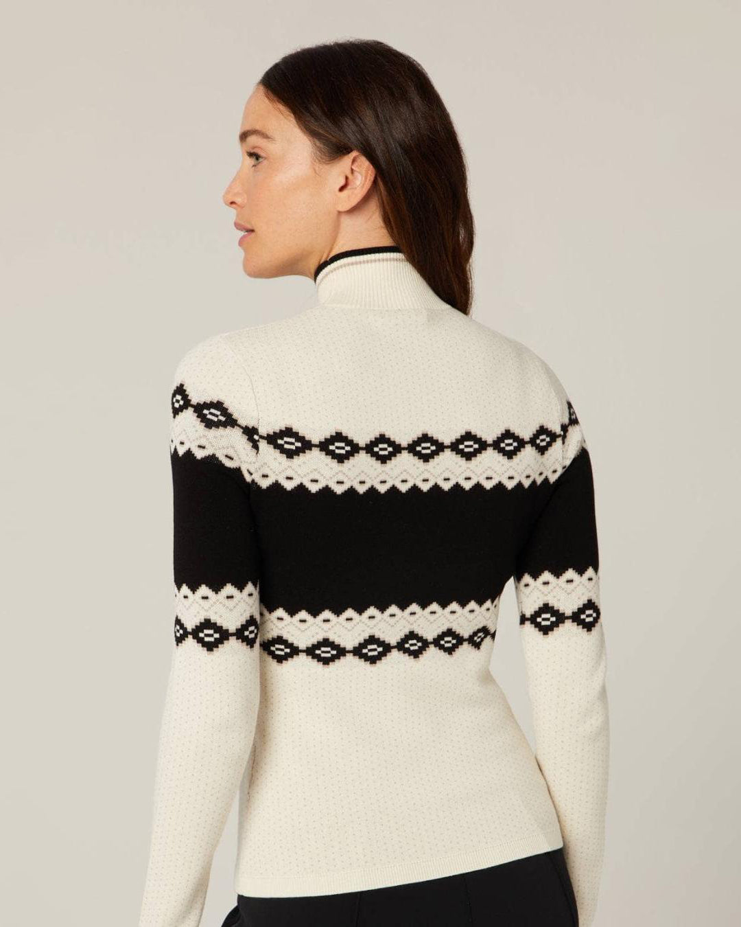 a woman wearing a fairisle black and white holiday sweater with the word 'Après' on it