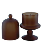candle in a brown holder with a cloche