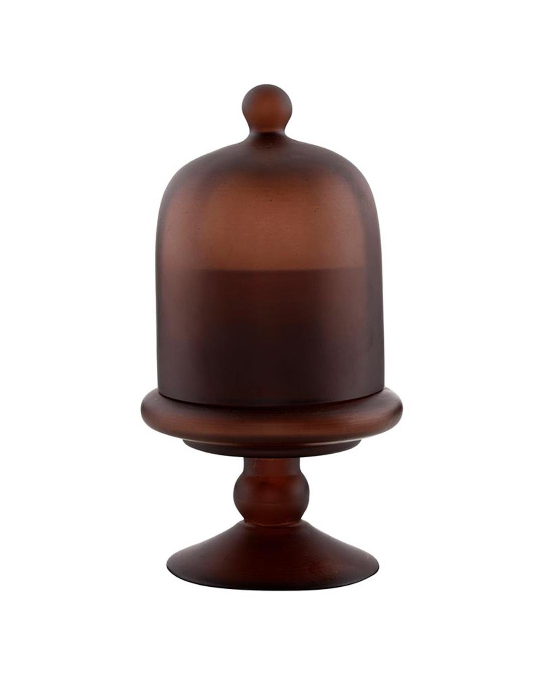 candle in a brown holder with a cloche