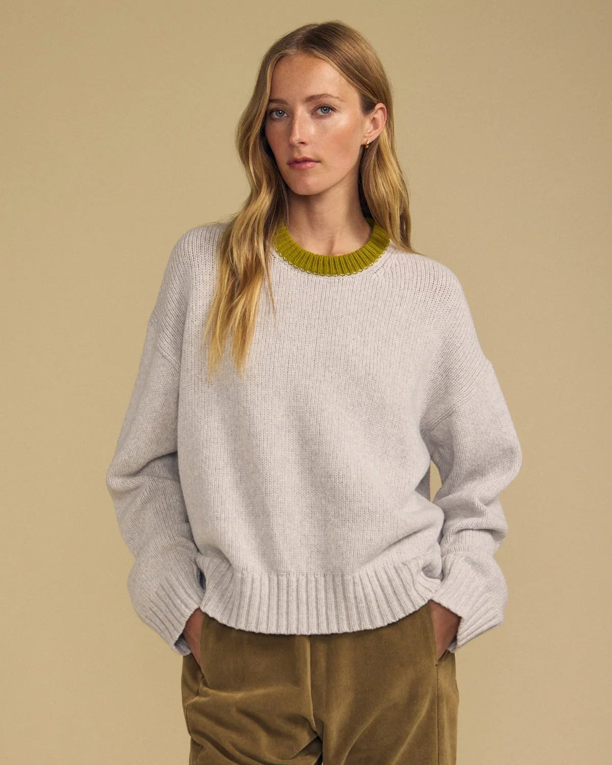 light grey sweater with green trim on neck