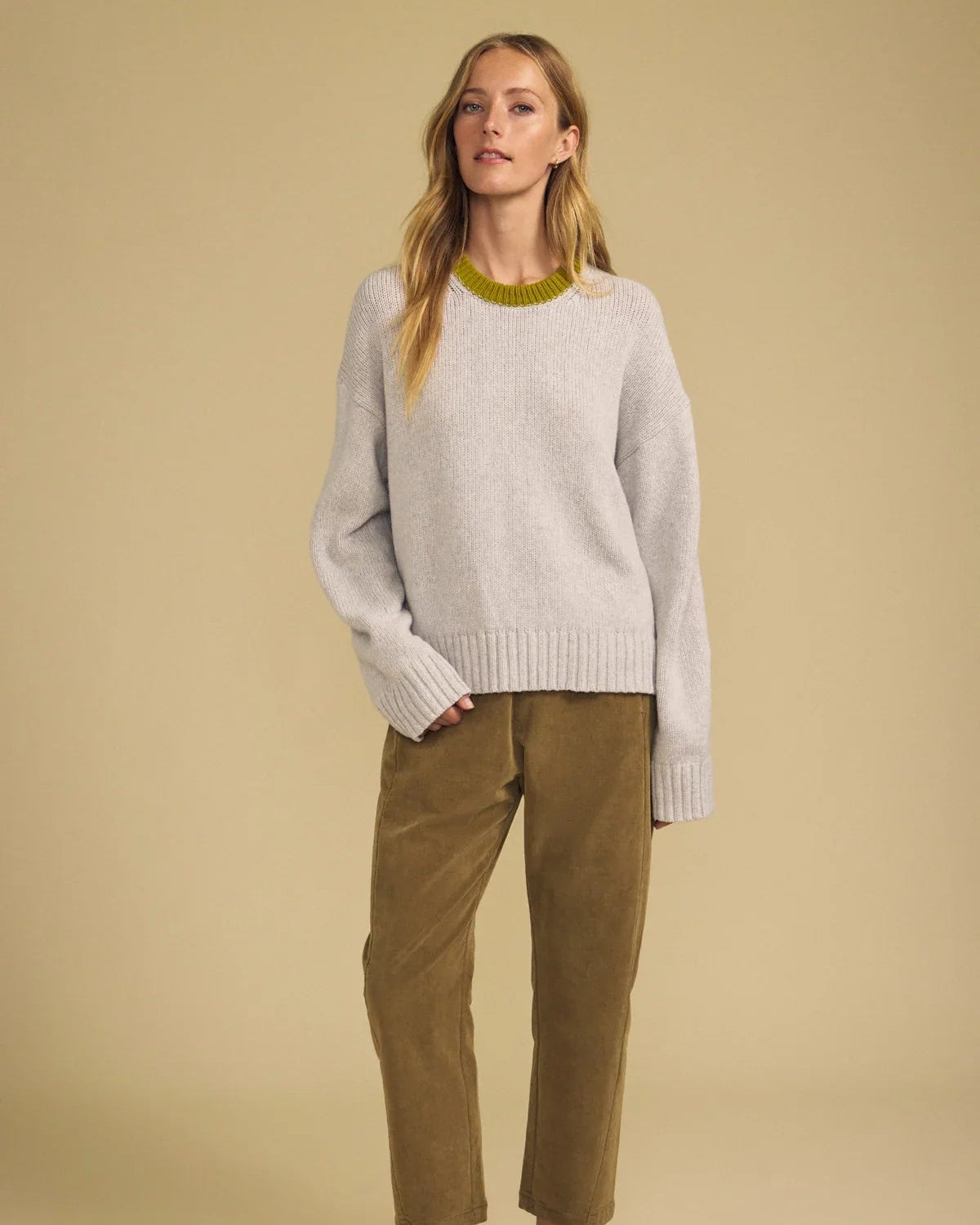 light grey sweater with green trim on neck