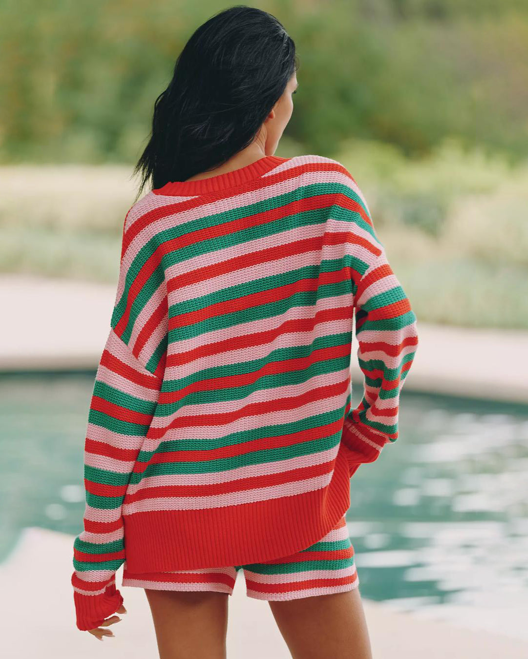 Woman wearing a red, green, and pink striped knit sweater