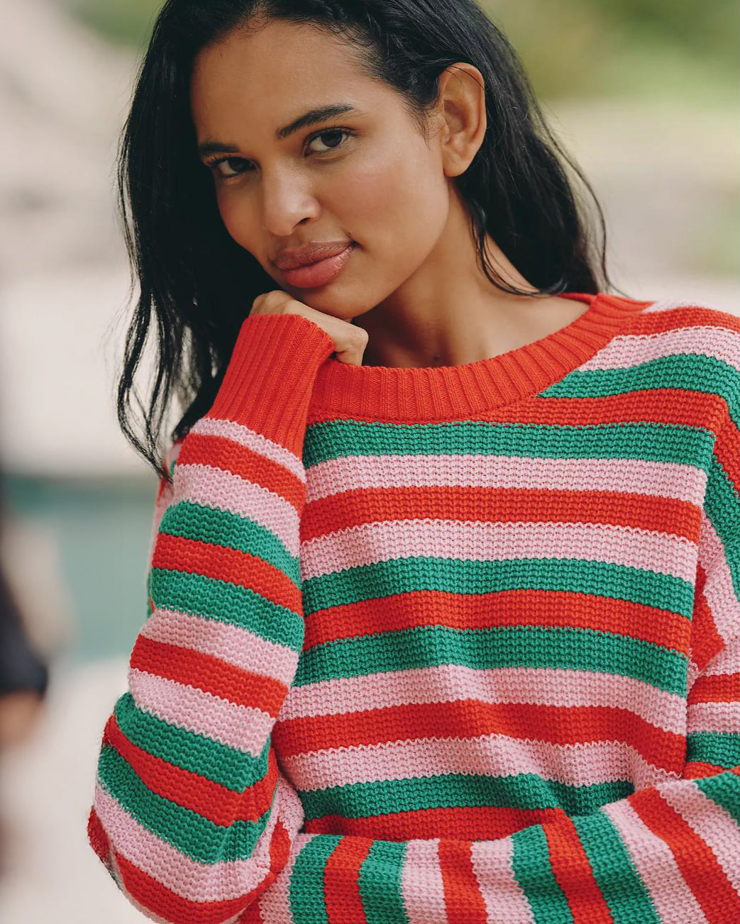 Woman wearing a red, green, and pink striped knit sweater
