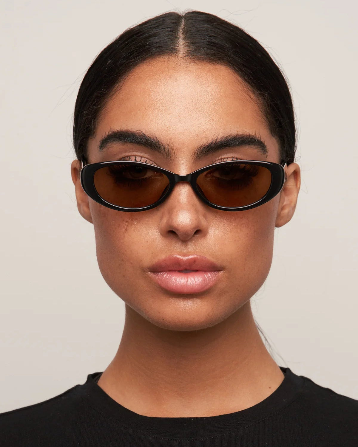 black oval sunglasses with brown lenses
