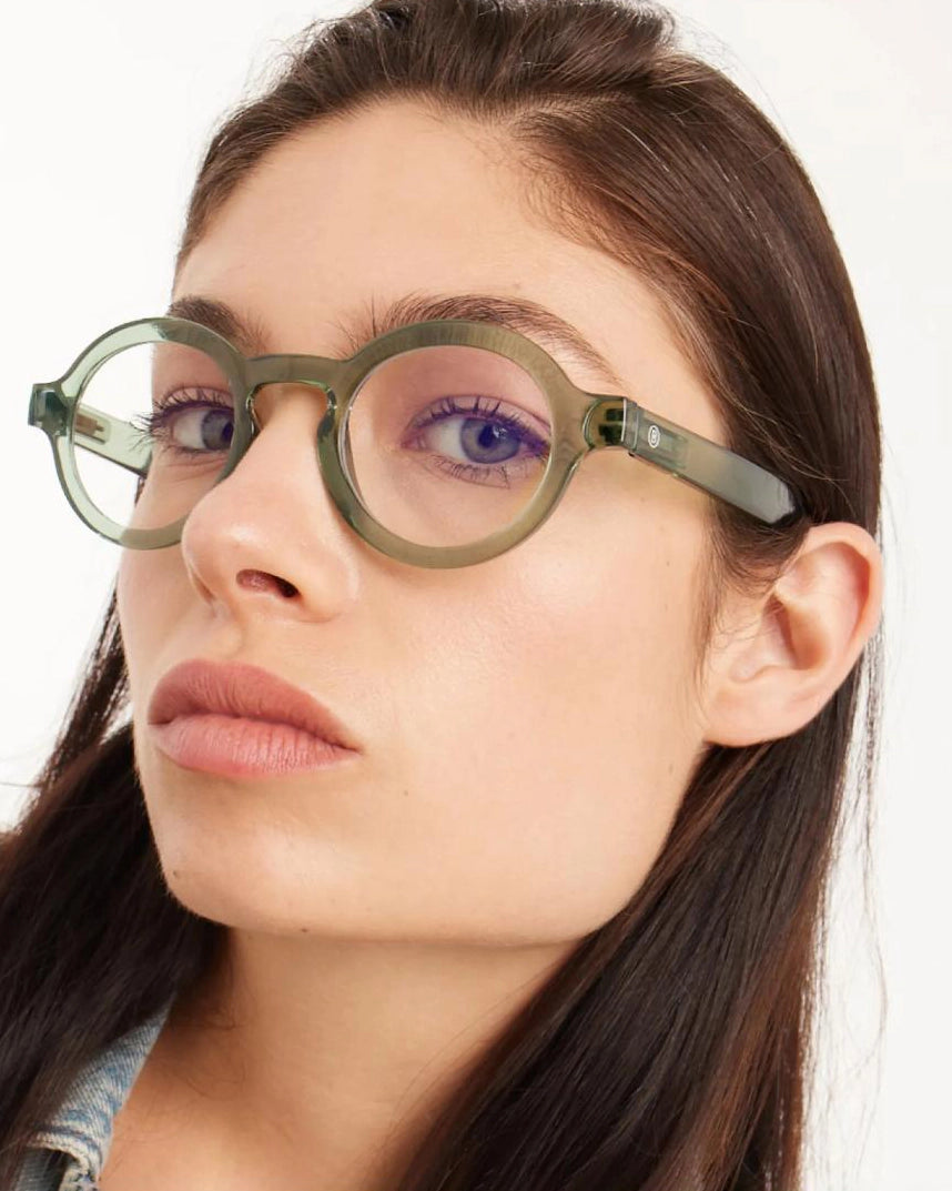 woman wearing a pair of green round framed eyeglasses for blue light by Barner