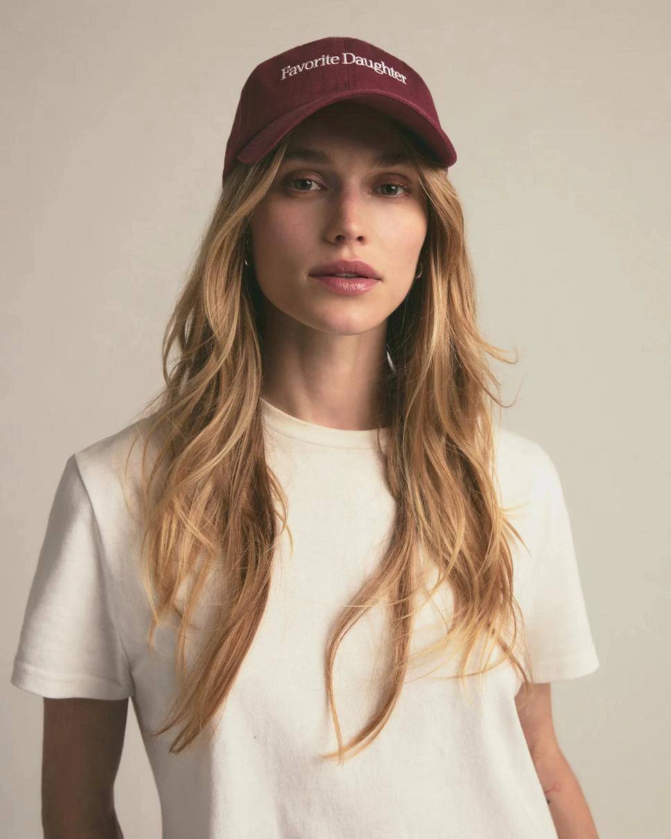 woman wearing a maroon baseball cap with 'Favorite Daughter' text on it