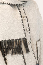 Close-up of a light grey coat with scarf