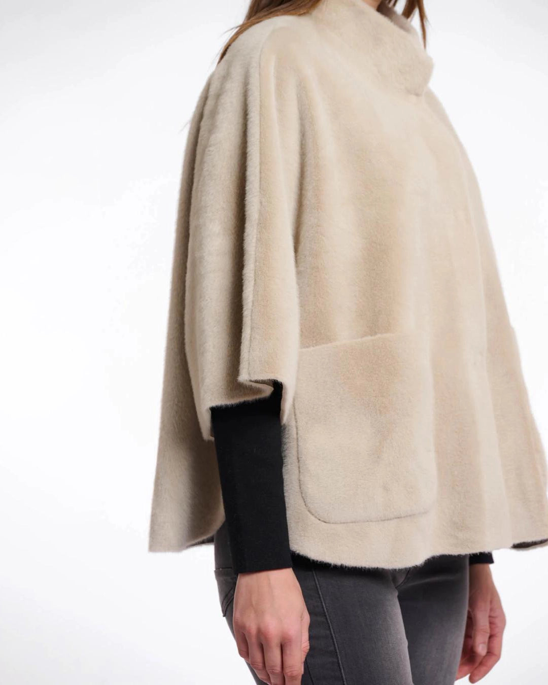 Woman wearing a beige faux fur cape in beige
