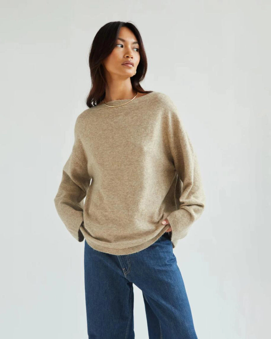 a woman wears a reversible cardigan sweater in beige