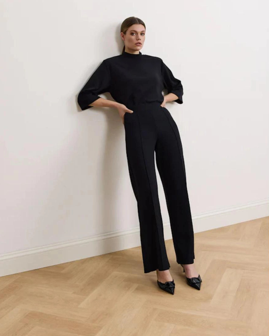 Woman wearing a black bracelet sleeve top with mock neck