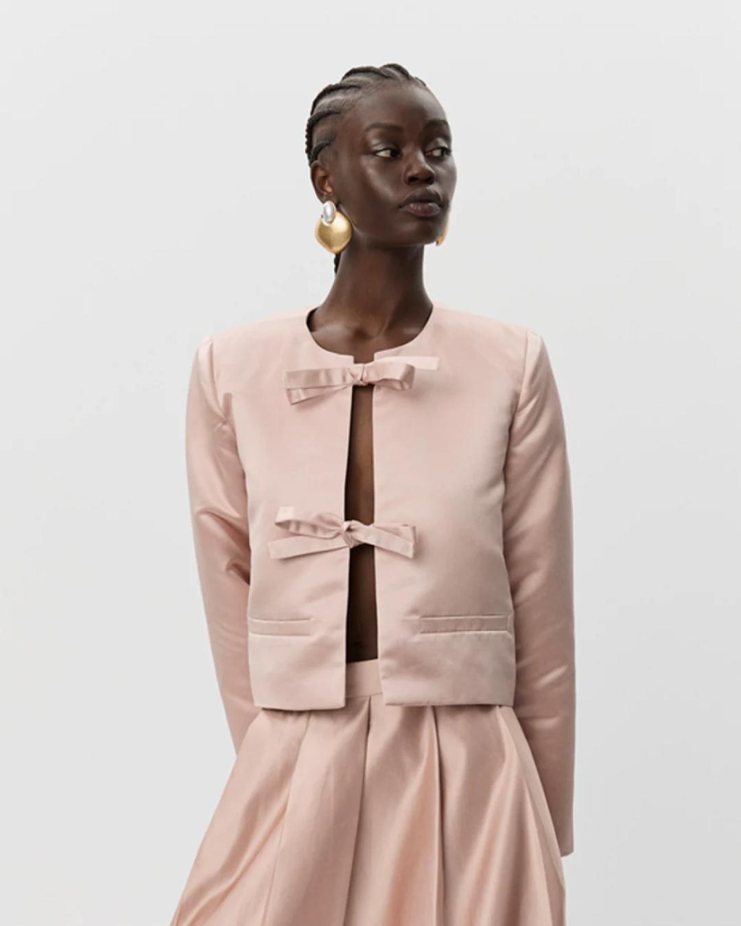 pink blazer jacket with two bows holding it together