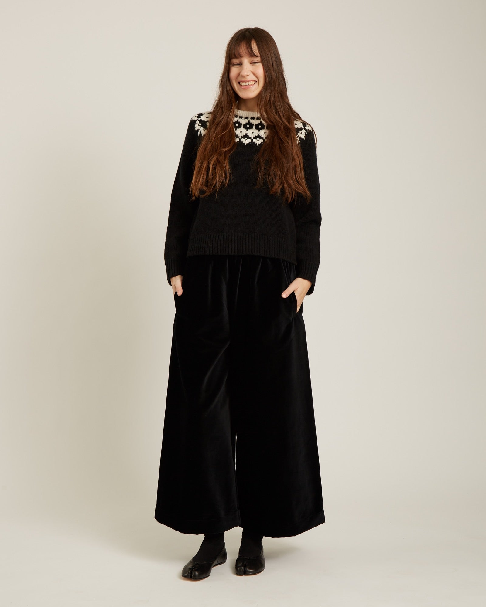 black sweater with a geometric design on the top in cream