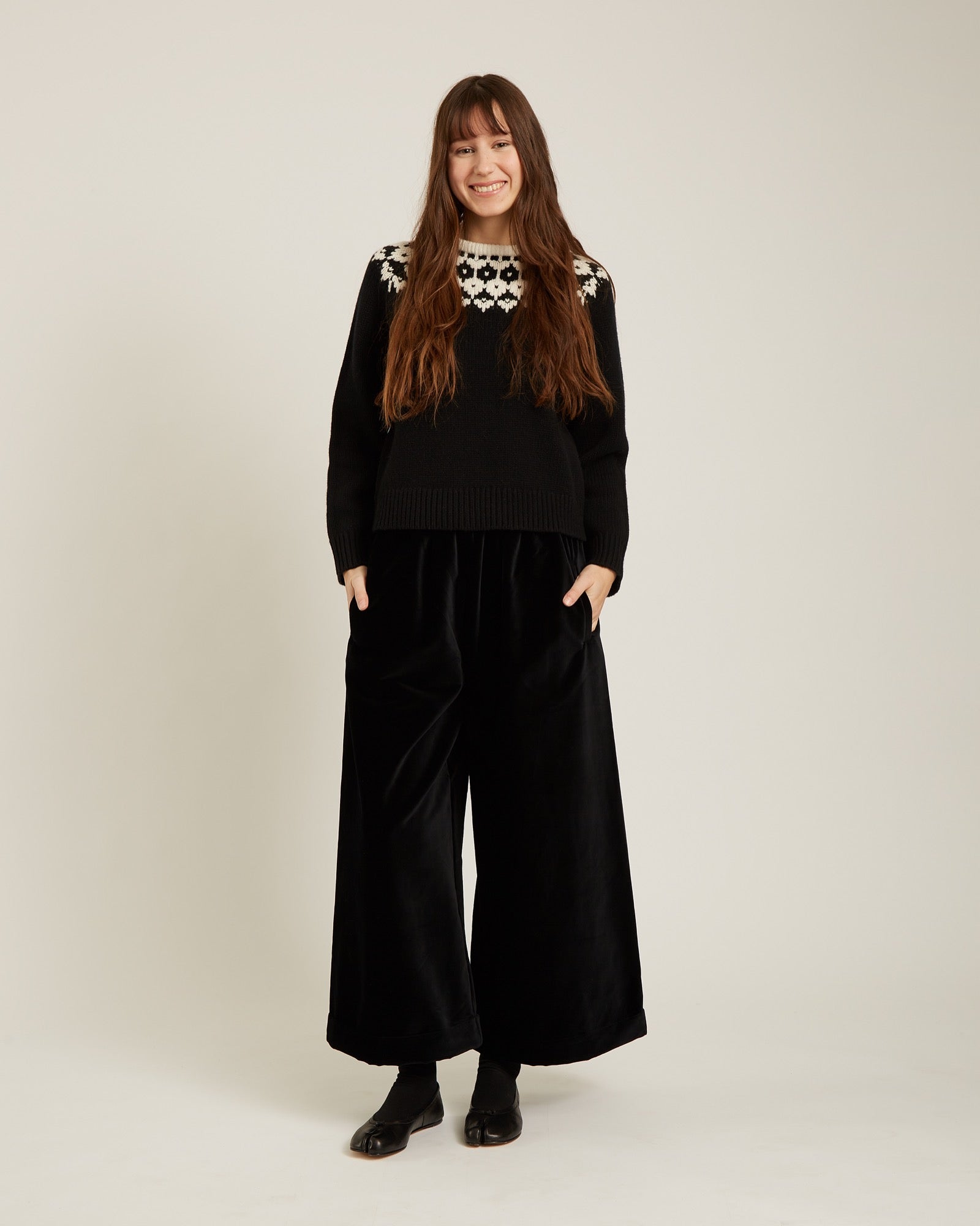 black sweater with a geometric design on the top in cream