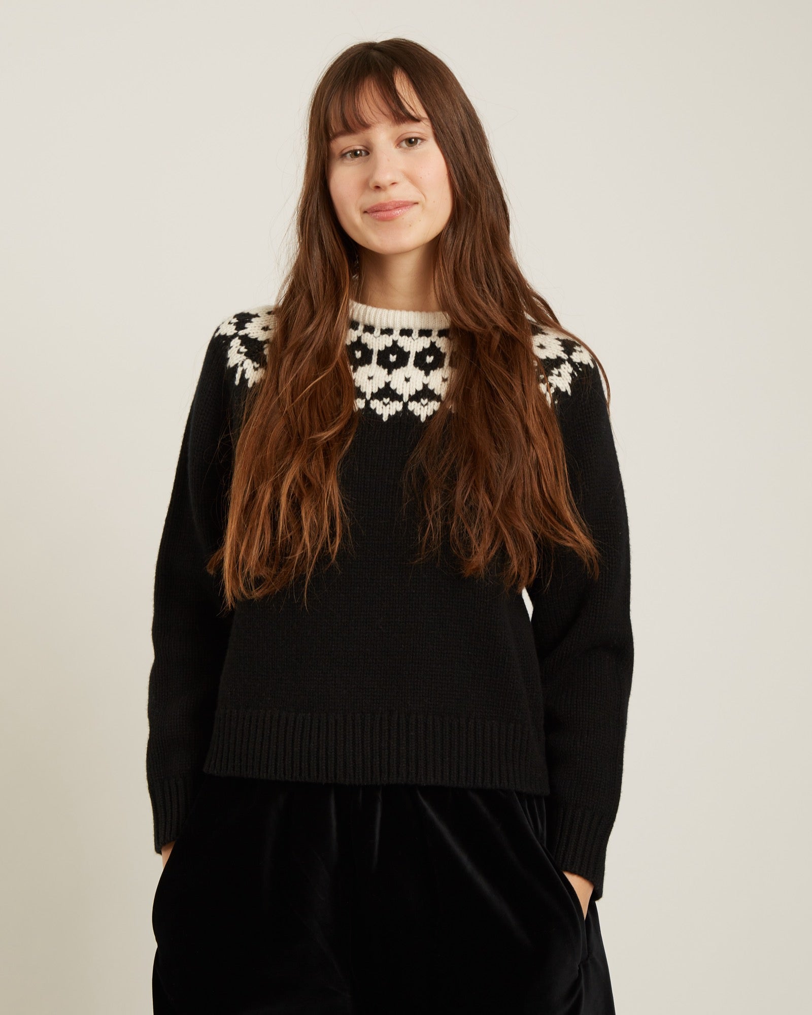 black sweater with a geometric design on the top in cream