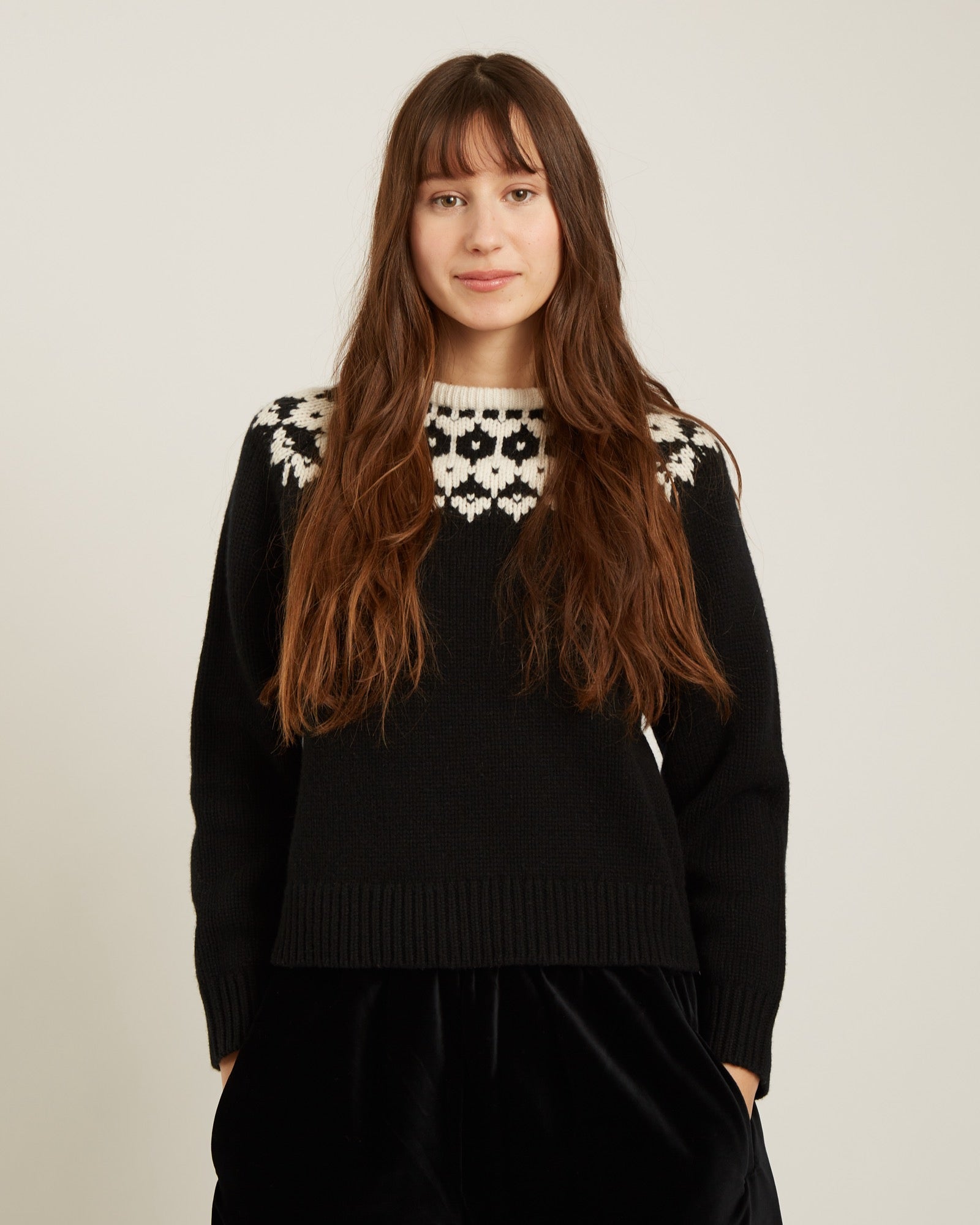 black sweater with a geometric design on the top in cream