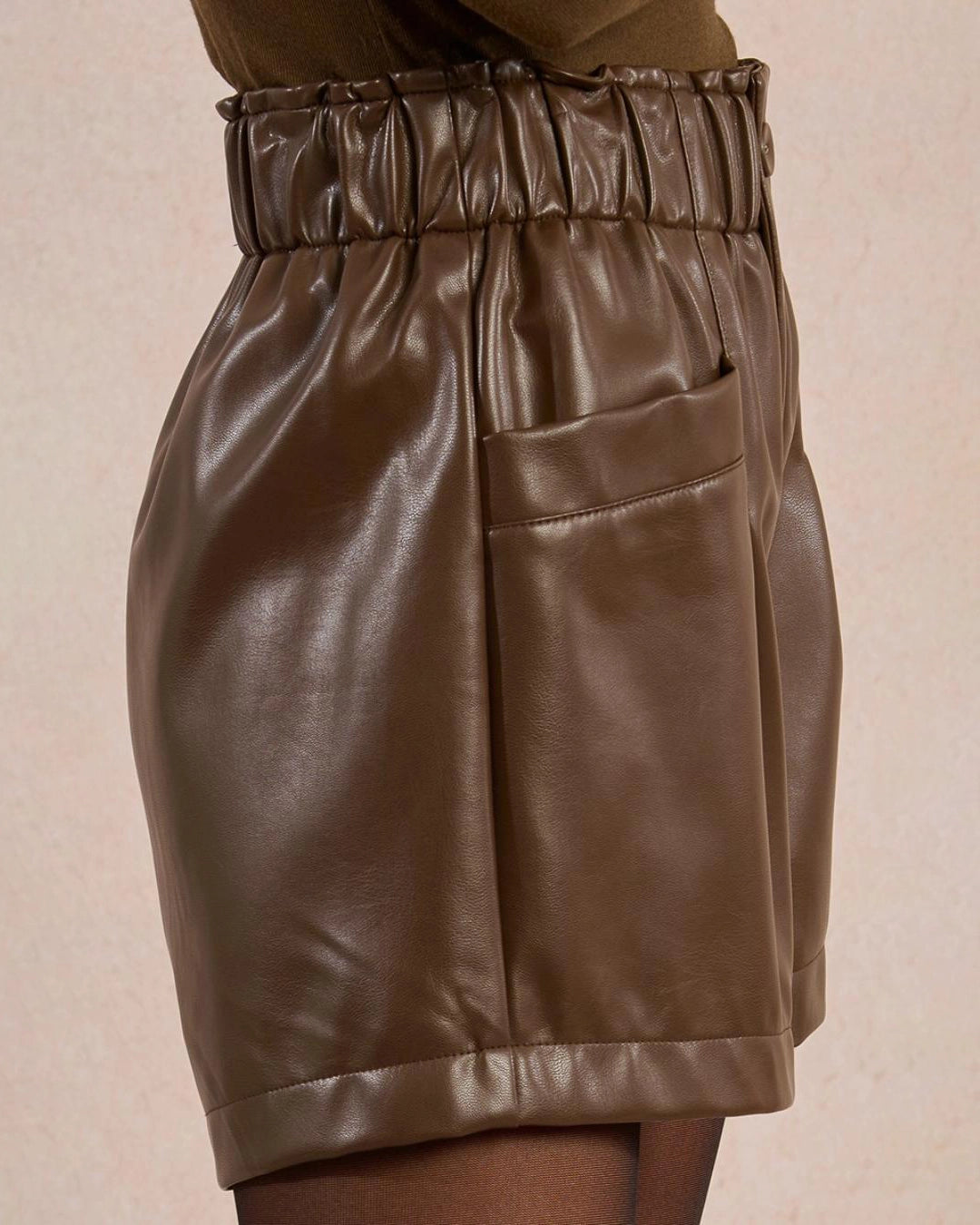 Woman wearing brown leather shorts